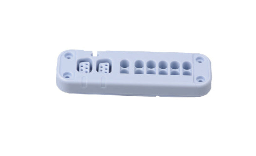 White plastic component with multiple holes on a white background