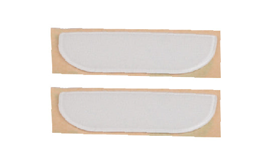 Two white half-moon shaped pads on beige cardboard background
