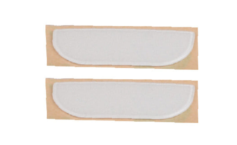 Two white half-moon shaped pads on beige cardboard background