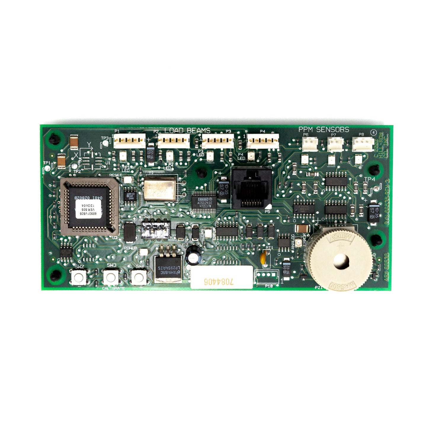 A green printed circuit board (PCB) assembly, which includes various electronic components such as capacitors, connectors, and integrated circuits.