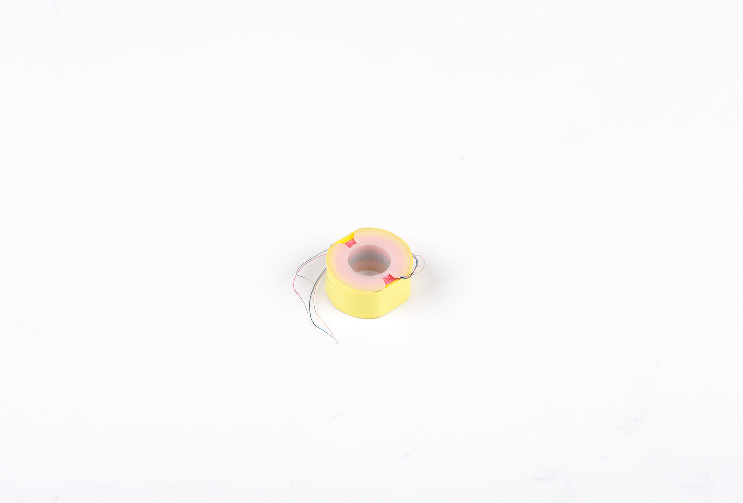 Small yellow and pink toy on a white background