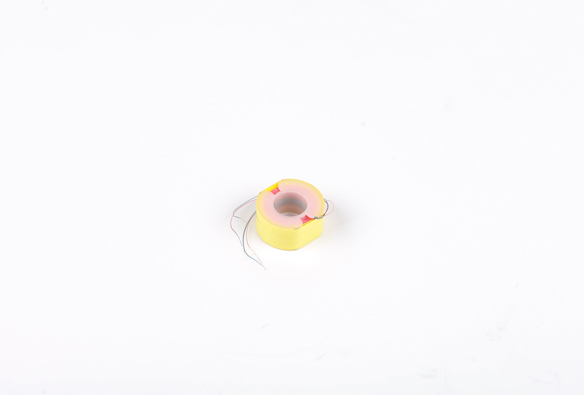 Small yellow and pink toy on a white background