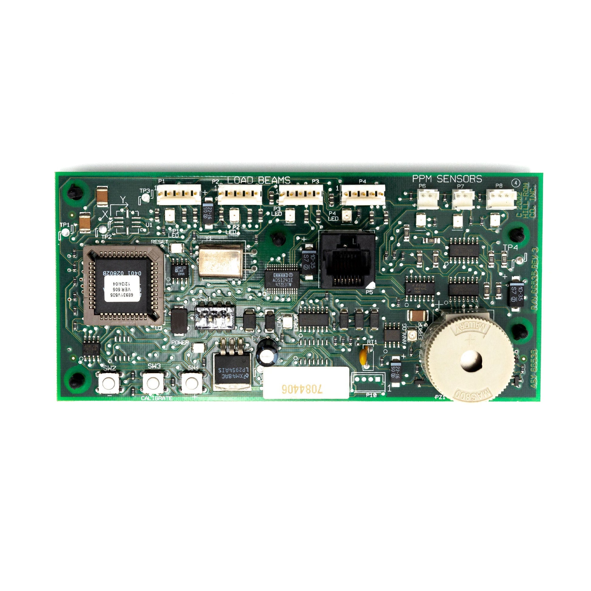 A green printed circuit board (PCB) assembly, which includes various electronic components such as capacitors, connectors, and integrated circuits.
