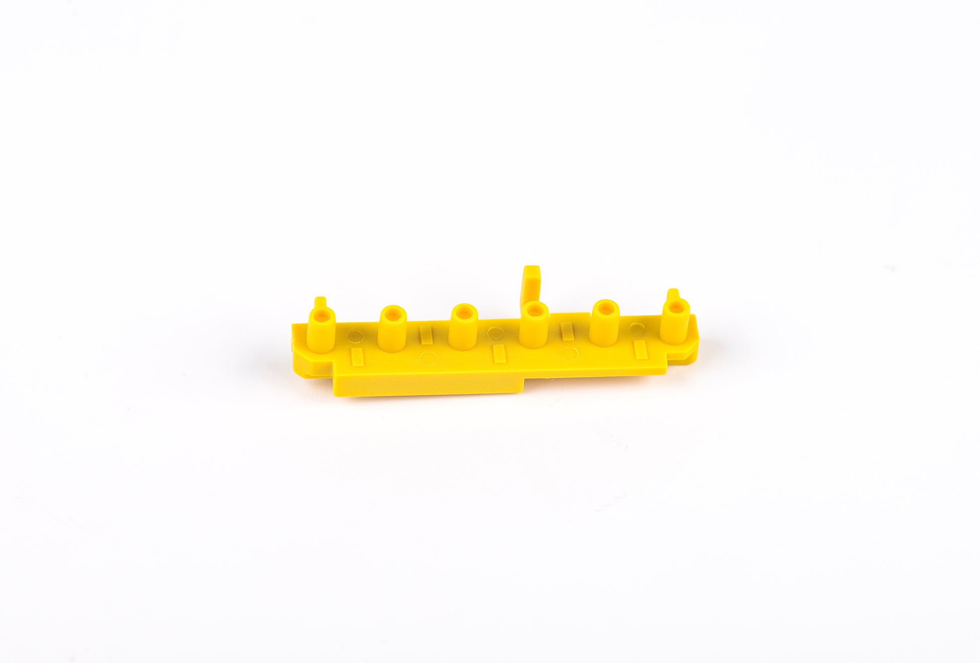 Yellow plastic component on a white background