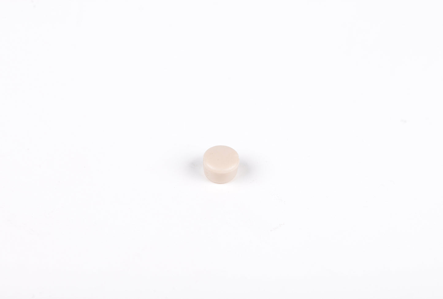Small beige round object on a white background
