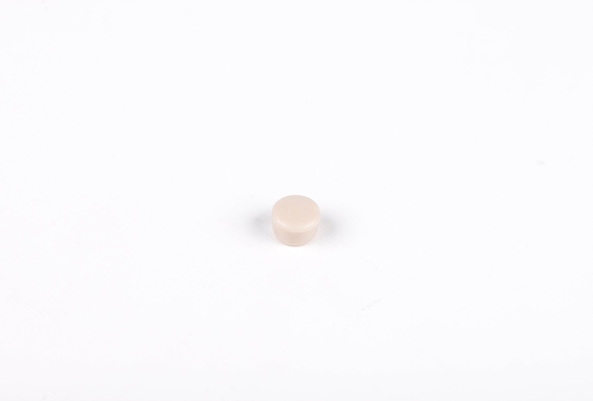 Small beige round object on a white background